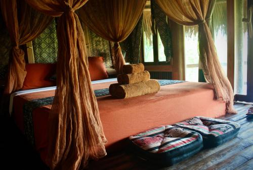 a bedroom with a canopy bed with a pile of towels at Lua Pu Luong in Pu Luong