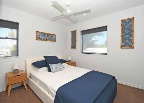 a bedroom with a bed and a ceiling fan at Luxurious Beachfront Apartment in Hervey Bay