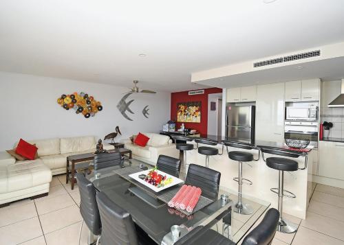 a kitchen and living room with a table and chairs at Luxurious Beachfront Apartment in Hervey Bay