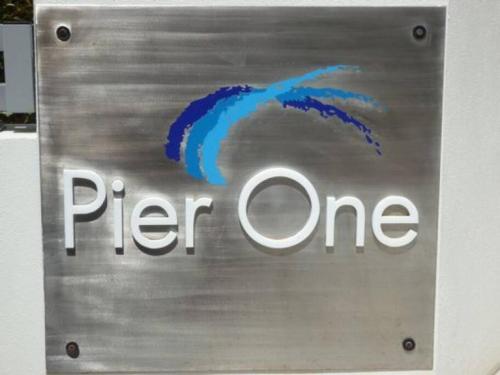 a sign for a pherone company on a wall at Luxurious Beachfront Apartment in Hervey Bay