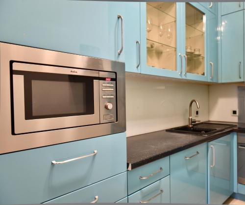 a kitchen with blue cabinets and a microwave at Be Inspired, Choose The Best! in Vienna