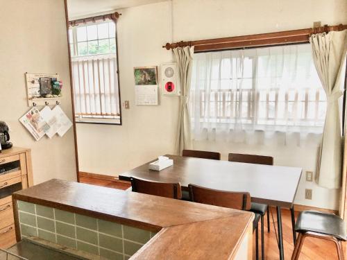 a dining room with a table and chairs at ゲストハウス奄美ルリカケス in Amami