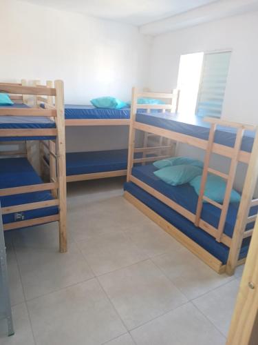 a room with three bunk beds with blue pillows at #Pousada São Paulo SP ótima localização in Sao Paulo