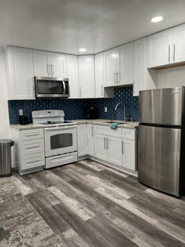 a kitchen with white cabinets and a stainless steel refrigerator at Crystal Sands Apartments in Ocean City