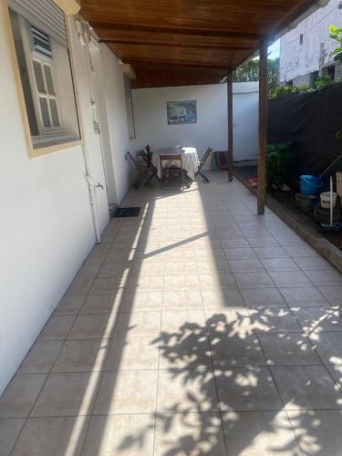 a patio with a table and shadows on the ground at La maison de la plage in Sainte-Luce