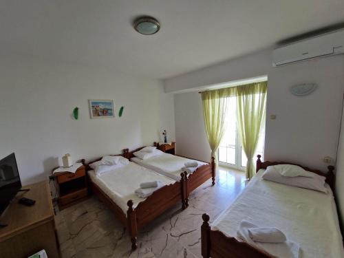 a bedroom with two beds and a window at Villa Gabriel in Pag