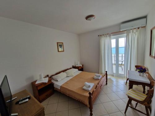 a bedroom with a bed and a desk and a television at Villa Gabriel in Pag