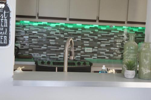 a kitchen counter with a sink and green lights at The Vue at Dos Marina in Fajardo