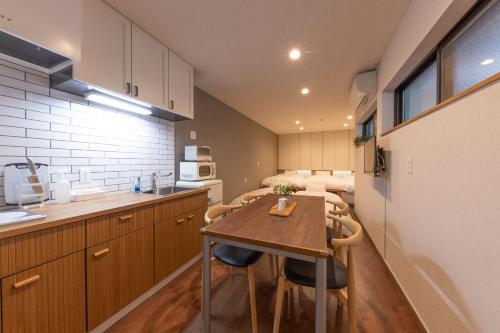 una pequeña cocina con mesa de madera y sillas en KAjette, en Takayama