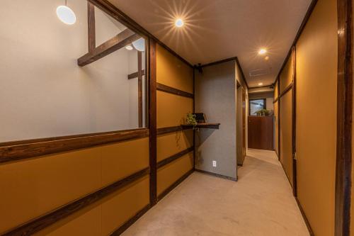 a hallway with yellow walls and a window at KAjette - Takayama Apartment Hotel in Takayama