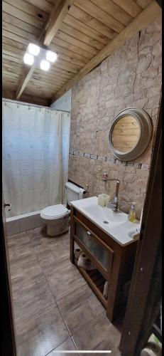 a bathroom with a sink and a toilet and a mirror at LA VECINDAD in Dique Luján