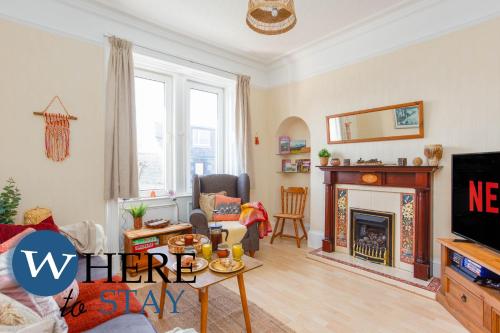 sala de estar con chimenea y TV en Bright 2bed apartment in Galashiels City Centre, en Galashiels