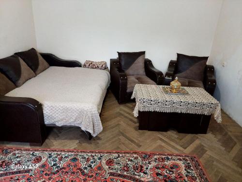 uma sala de estar com um sofá e uma mesa em Дили Дом em Dilijan