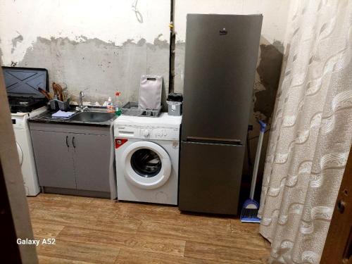 a kitchen with a refrigerator and a washing machine at Dili Dom in Dilijan