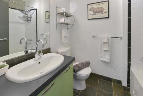 a white bathroom with a sink and a toilet at Harbourview Executive Condo in Victoria