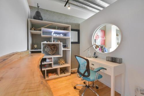 Zimmer mit einem Schreibtisch, einem Stuhl und einem Spiegel in der Unterkunft Harbourview Executive Condo in Victoria