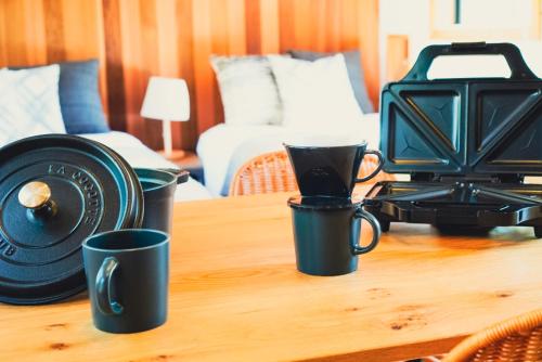 a table with three coffee cups and a toaster at サウナバーベキュージャグジー完全貸し切りという贅沢大人の秘密基地#01 in Miyota