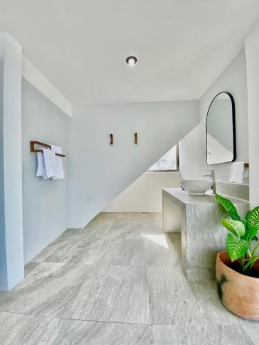 a white bathroom with a sink and a mirror at Monaco in San Pedro La Laguna