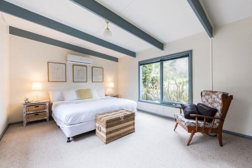 a bedroom with a bed and a chair and a window at Panorama Retreat & Resort in Kalorama
