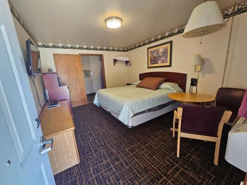 Habitación de hotel con cama y mesa en Cle Elum Travelers Inn, en Cle Elum