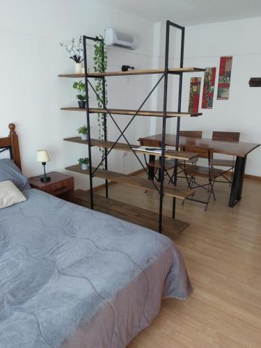 a room with a bed and a table and a desk at Hermoso depto en el centro de Mar del Plata in Mar del Plata