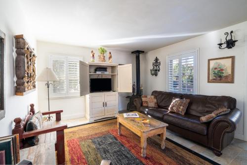 a living room with a leather couch and a coffee table at Casita de Jeanetta in Santa Fe