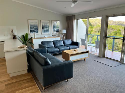 a living room with a couch and a table at BlueWater Apartments in Merimbula