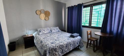 a bedroom with a bed and a table and a window at Hostal Backpackers Travelero in Santa Cruz de la Sierra