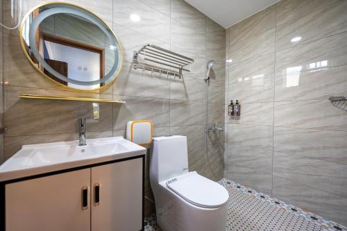 a bathroom with a toilet and a sink and a mirror at 波西塔諾villa民宿 全新旅店市中心 歐式別墅 親子住宿 in Xiaoliuqiu
