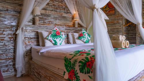 een slaapkamer met een hemelbed bij Kayuna Villa in Nusa Penida