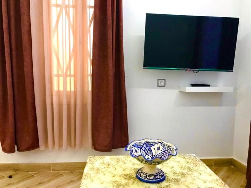 um vaso sentado numa mesa em frente a uma televisão em Casa murcia em Chefchaouen