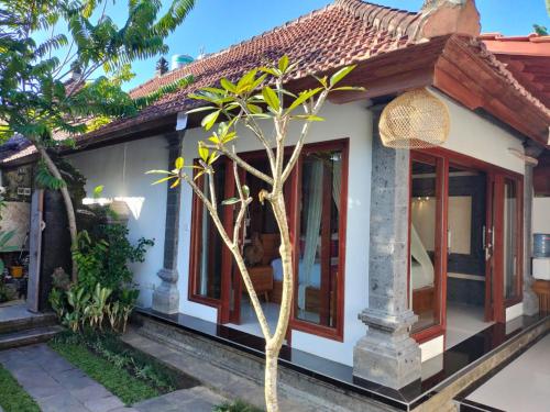 a small house with a tree in front of it at Baruna Sari Villa in Ubud