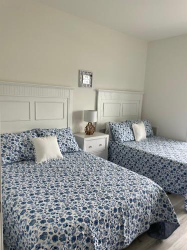 1 dormitorio con 2 camas con sábanas azules y blancas en Sunshine Manifested, en Lewes