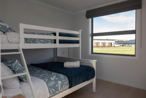 a bedroom with a bunk bed and a window at Two Fantails in Lake Tekapo