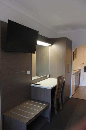 a kitchen with a counter and a table and chairs at Aston Motel Yamba in Yamba