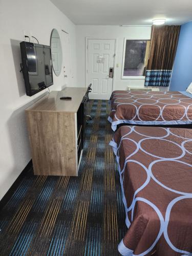 a hotel room with two beds and a television at Super 8 by Wyndham Shreveport in Shreveport