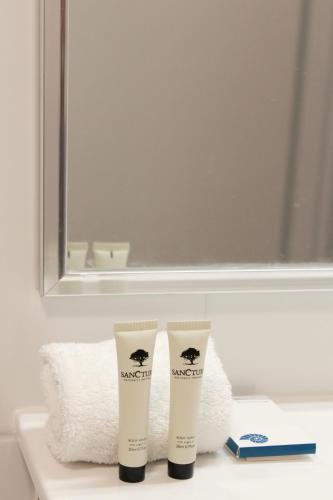 two tubes of sunscreen sitting on a bathroom counter at Aston Motel Yamba in Yamba