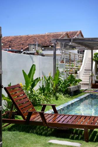 a wooden bench sitting next to a swimming pool at NGÀI Villa in Phu Yen