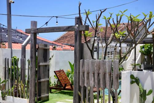 a wooden gate in a garden with a bench at NGÀI Villa in Phu Yen