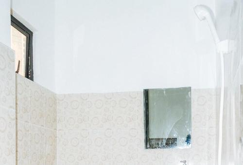 a bathroom with a mirror and a shower at Magabelle Guesthouse in Cebu City