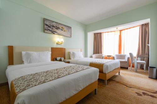 a hotel room with two beds and a window at Shanshui Trends Hotel - Huaqiangbei in Shenzhen