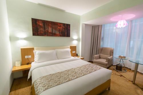 a hotel room with a bed and a chair at Shanshui Trends Hotel - Huaqiangbei in Shenzhen