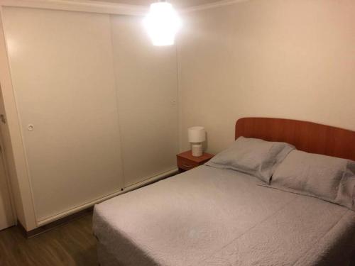 1 dormitorio con 1 cama y una luz en la pared en Departamento para alojamiento en sector norte, en Antofagasta