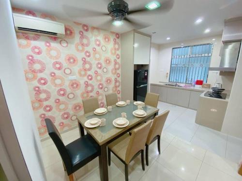 una sala da pranzo con tavolo e sedie e una cucina di A05 SkyBlue Desa Tebrau a Johor Bahru