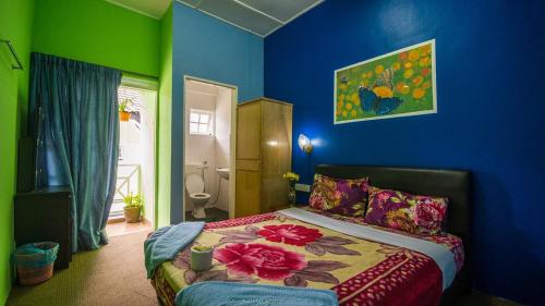 een slaapkamer met blauwe en groene muren en een bed bij Rose Haven Hotel in Cameron Highlands