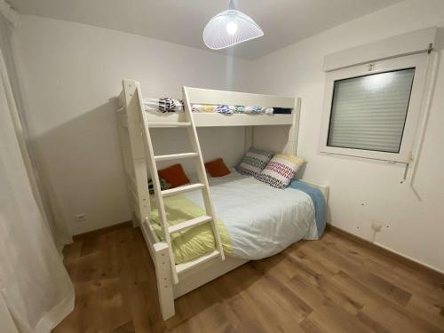 une chambre avec un lit superposé avec une échelle dans l'établissement Appartement RDC face à la mer avec balcon et parking privatif - FR-1-672-26, à Merlimont
