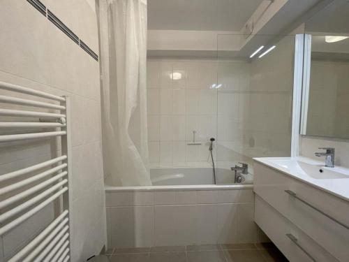 une salle de bain blanche avec une baignoire et un lavabo dans l'établissement Bel Appartement T2 en Centre-Ville d'Arcachon avec Balcon, à 200m de la Plage et Proche de la Gare - FR-1-474-243, à Arcachon