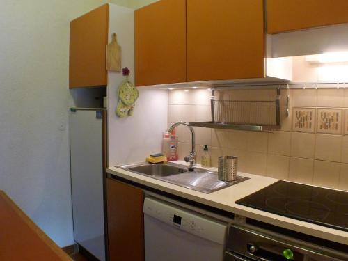 une cuisine avec un évier et un réfrigérateur dans l'établissement Appartement confort & lumineux avec balcons, animaux admis et parking couvert - FR-1-629-126, à Samoëns