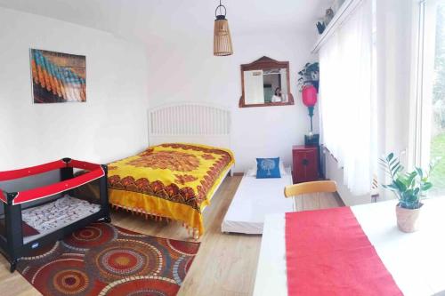 a bedroom with a bed and a red and yellow blanket at Pipin’s Studio in Ostermundigen