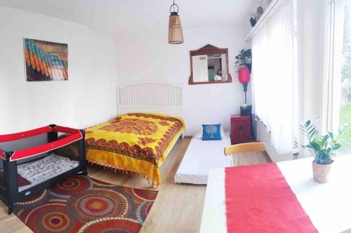 ein Schlafzimmer mit einem Bett und einer rot-gelben Decke in der Unterkunft Pipin’s Studio in Ostermundigen